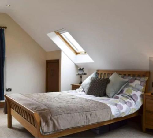 a bedroom with a large bed with a skylight at Surrounded by fields just 3 miles from Stratford - upon Avon - Alveston Pastures Cottage in Stratford-upon-Avon