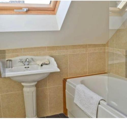 a bathroom with a sink and a bath tub at Surrounded by fields Alveston Pastures Cottage in Stratford-upon-Avon