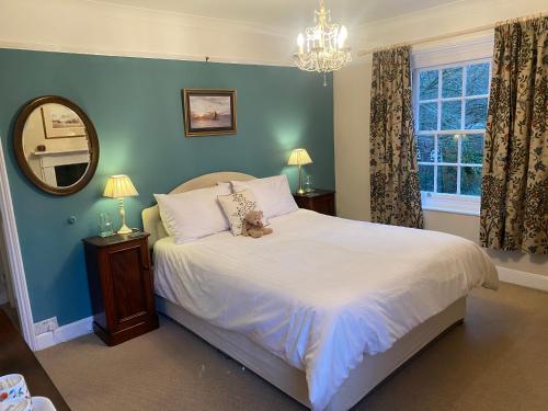 a bedroom with a bed with a teddy bear on it at Mill House Bed and Breakfast in Cromer