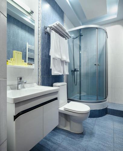 a bathroom with a sink and a toilet and a shower at Alpina Resort by Stellar Hotels, Tsaghkadzor in Tsaghkadzor