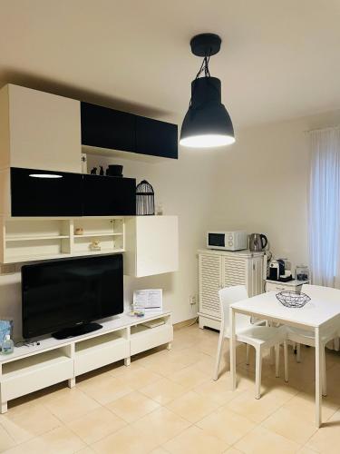 ein Wohnzimmer mit einem Tisch und einem großen TV in der Unterkunft Pretty Little Home in Mailand