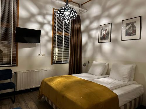 Schlafzimmer mit einem Bett und einem Kronleuchter in der Unterkunft Hotel Buren in West-Terschelling