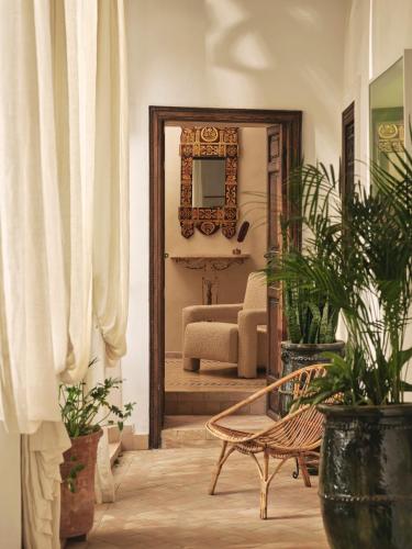 a mirror in a living room with plants and a chair at IZZA Marrakech in Marrakech