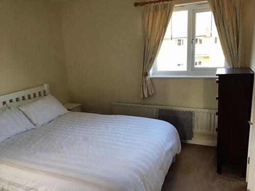 una camera con un letto bianco e una finestra di Beautiful Penthouse Apartment a Walton-on-Thames