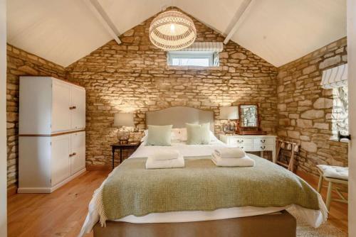 a bedroom with a large bed with towels on it at Oxbow Cottage in Stow on the Wold