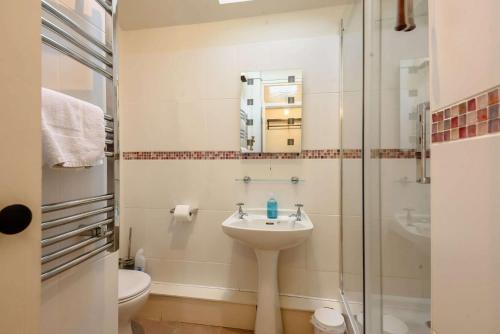 een badkamer met een wastafel en een douche bij Oxbow Cottage in Stow on the Wold