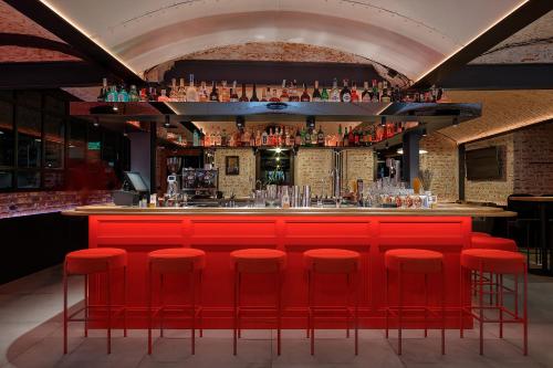 a bar with red bar stools in a room at Ribas Rooms Ferenc Lviv in Lviv
