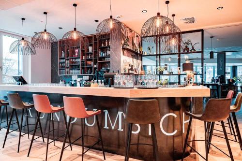 a bar in a restaurant with pink stools at Boardinghouse Das RUNDUM in Bad Reichenhall