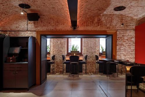 um quarto com mesas e cadeiras e paredes de tijolo em FERENC Hotel & Restaurant em Lviv