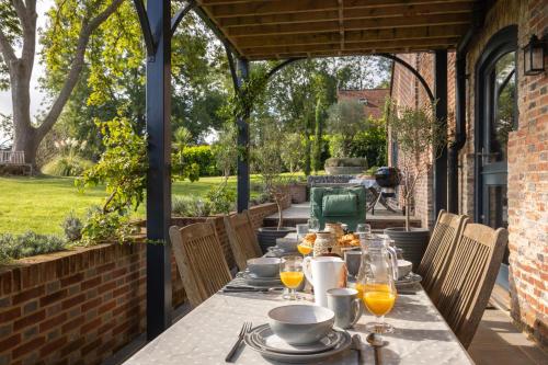 - une table avec des assiettes de nourriture sur une terrasse dans l'établissement Burnt House Alfriston, Sussex (London-95 mins), à Alfriston