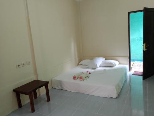 een slaapkamer met een bed met twee knuffels erop bij MBE BALENG KU in Mangsit