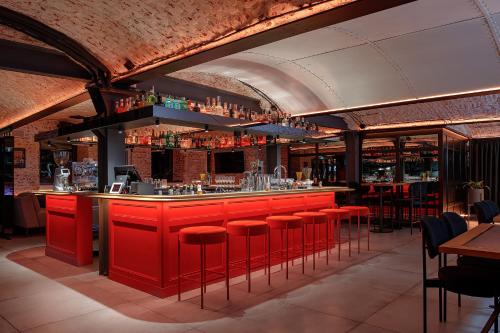 a bar with red bar stools in a restaurant at FERENC Hotel & Restaurant in Lviv