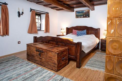 ein Schlafzimmer mit einem Bett und einer Holzkiste in der Unterkunft Romantic Cottage - Your Hide Away in Cserszegtomaj