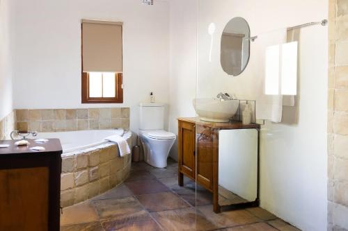 a bathroom with a tub and a sink and a toilet at Aan de Heuvel Self-Catering Cottages in Swellendam