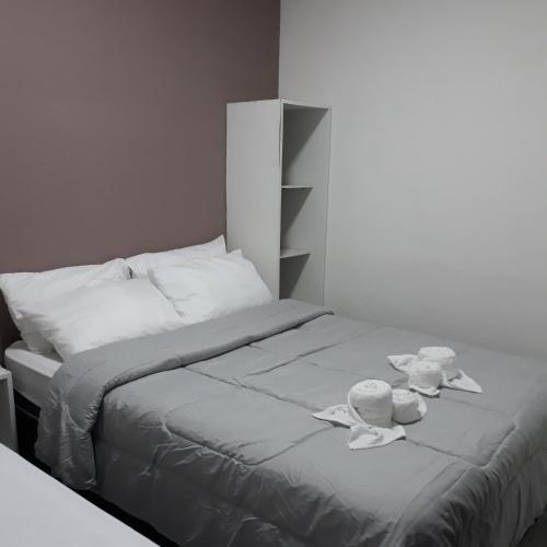 uma cama com duas toalhas e duas chávenas em Pousada Caribe Milagrense em São Miguel dos Milagres