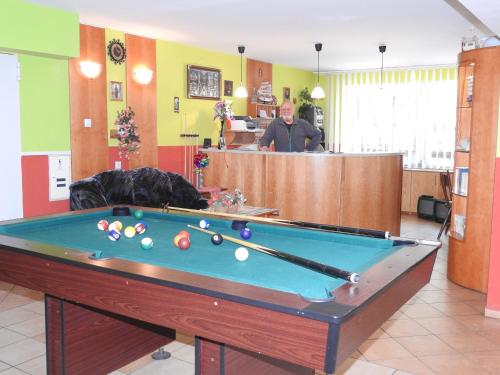 a man standing in a room with a pool table at SEA-PORT Resort in Łeba