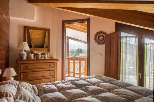 a bedroom with a bed and a dresser and a window at Accogliente appartamento su 2 piani Rocca di Mezzo in Rocca di Mezzo