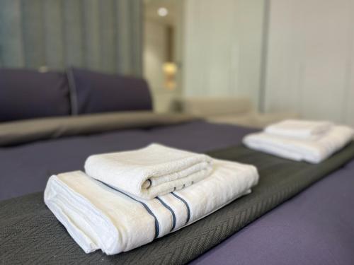 two stacks of towels sitting on top of a bed at Modern Studio- 115 Westwood Al furjan in Dubai