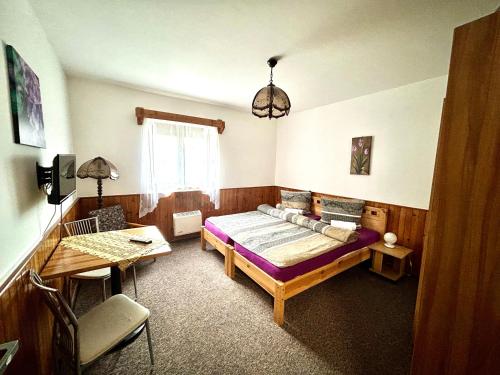 a bedroom with a bed and a table and a desk at Penzion Chaloupka in Prague
