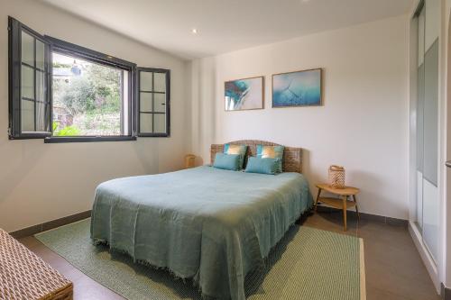 une chambre avec un lit et une fenêtre dans l'établissement Villa Ghjunchitu - Vue mer et Piscine privée proche de l'ile rousse, à Corbara