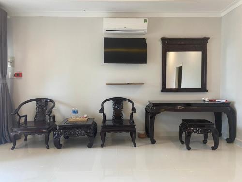a room with two chairs and a table and a mirror at H&ograve;n Cau Resort & Restaurant in Tuy Phong