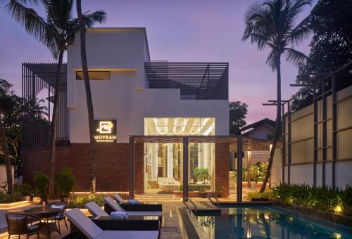 a house with a swimming pool next to a building at Moyrah By Greenpark in Anjuna