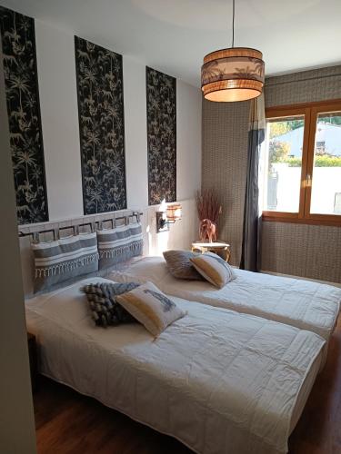 une chambre avec un grand lit blanc avec des oreillers dans l'établissement Villa les Doms, à Mazan