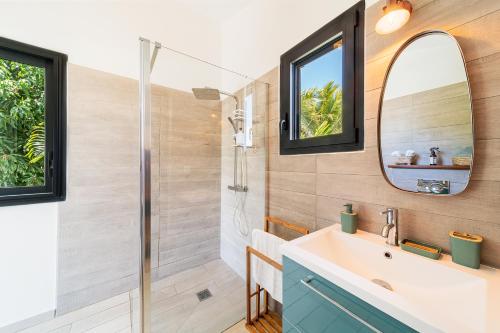 a bathroom with a shower and a sink and a mirror at Villa Sharma 5* : Détente et bien être. in Saint-Pierre