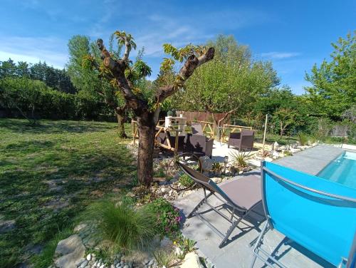 un jardin avec un arbre et une piscine dans l'établissement Villa les Doms, à Mazan