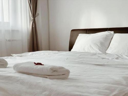 a white bed with white sheets and towels on it at Joy City Stay Victoriei 7E-30 2 in Timişoara