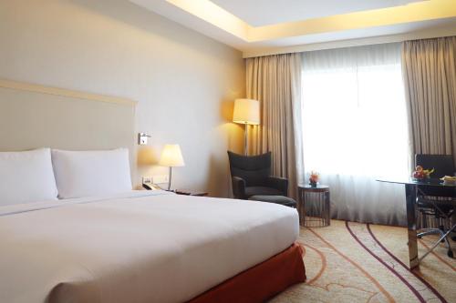 a hotel room with a bed and a desk and a window at DoubleTree by Hilton Gurgaon New Delhi NCR in Gurgaon