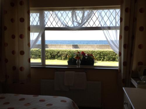 a bedroom window with a view of the eiffel tower at Seaside Accomodation in Quilty