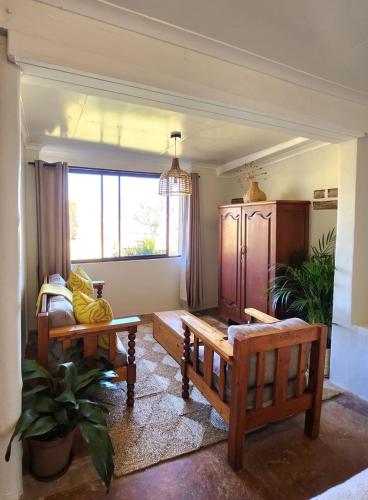 a living room with two benches and a window at Berghouse and Cottages in Langkloof