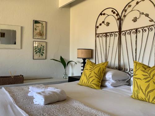 a bedroom with a large white bed with yellow pillows at Berghouse and Cottages in Langkloof