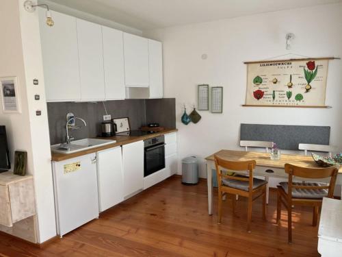 a kitchen with white cabinets and a wooden table at Holiday apartment Weinberghäusle in Sasbach am Kaiserstuhl