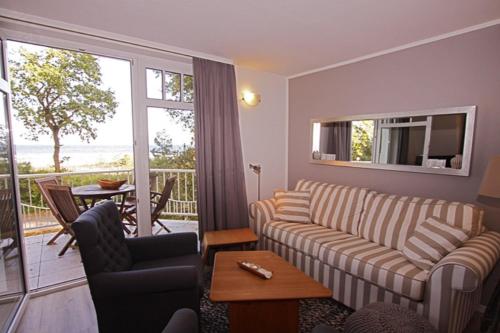 d'un salon avec un canapé et des chaises ainsi que d'un balcon. dans l'établissement Strandvilla Drei Mäderl Haus, à Boltenhagen