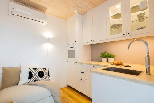 una pequeña cocina con armarios blancos y fregadero en Good Spot Zieleniec Twin Eco 03 en Duszniki Zdrój