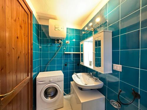W łazience znajduje się pralka i umywalka. w obiekcie Domus Tom Apartment with sea view Villasimius w mieście Villasimius