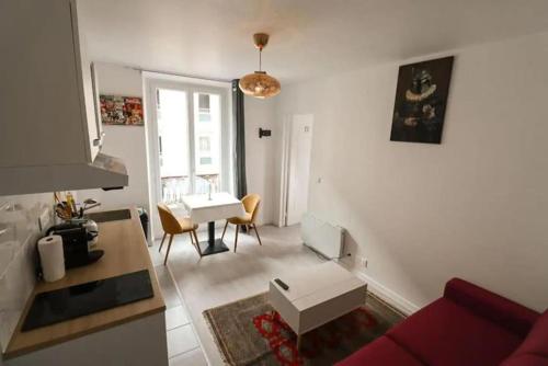een woonkamer met een rode bank en een tafel bij Appartement 4 personnes Oberkampf in Parijs