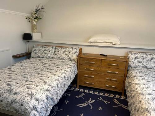 a bedroom with a bed and a dresser with a dresser at Alpaca Lodge in Sittingbourne