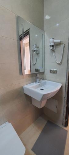 uma casa de banho com um lavatório branco e um espelho. em Le Petit Bijou em Tétouan
