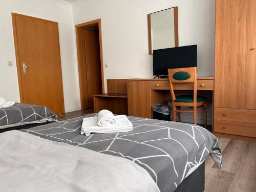 1 dormitorio con 1 cama y escritorio con ordenador en Hotel & Restaurant Dalmacija Polch, en Polch