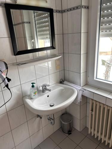 a bathroom with a sink and a mirror and a window at Hotel & Restaurant Dalmacija Polch in Polch