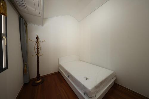 una piccola camera con un letto bianco in un angolo di Park Art Villas a Buyeo