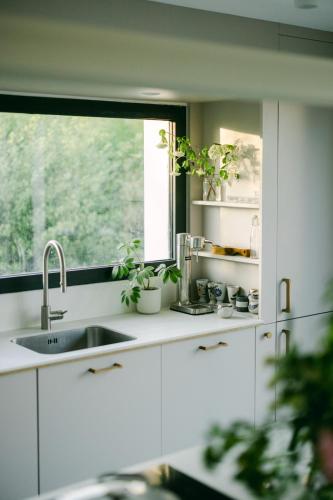 une cuisine avec un évier et une fenêtre dans l'établissement Maison Passage, à La Trinité-sur-Mer