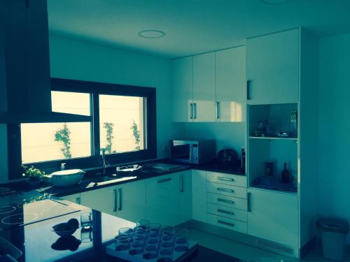 a kitchen with blue walls and white cabinets at Cecile's Villa in Casal do Pardo