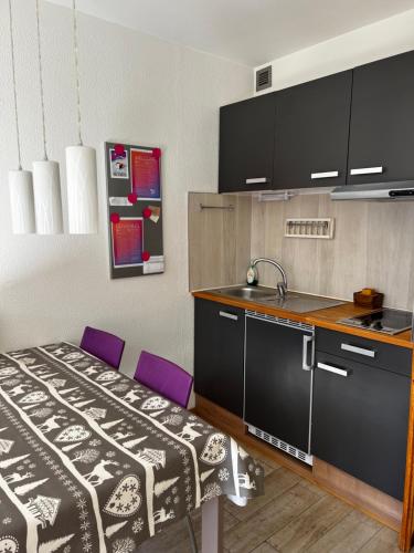 - une cuisine avec une table et des chaises violettes dans la chambre dans l'établissement Residence Ciel Bleu - Fraz Pos, à Aoste