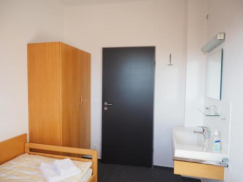 1 dormitorio con cama, lavabo y puerta en Haus Ohrbeck, en Georgsmarienhütte