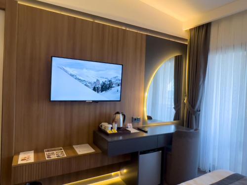 a hotel room with a television on a wall at Sera Lake Center Hotel in Akcaabat