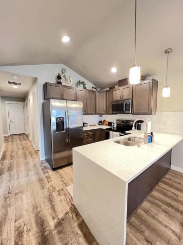 a kitchen with stainless steel appliances and wooden cabinets at Modern Style KING bed Free Wi-Fi with Garage in Spokane Valley